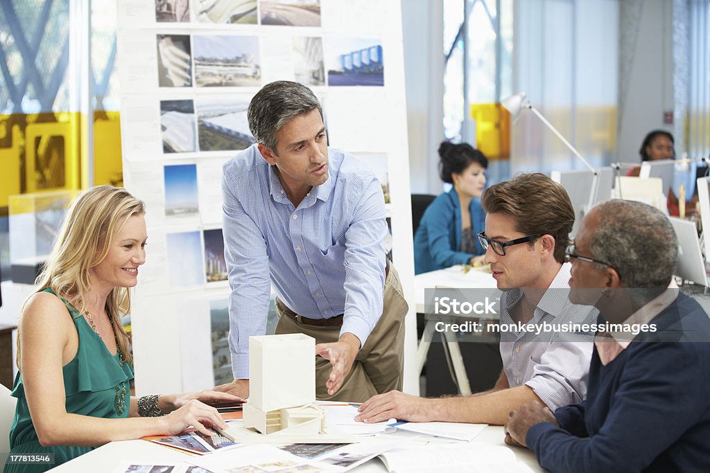 Group discussing ideas and meeting in an architect's office Workers Having Meeting In Architects Office 20-29 Years Stock Photo