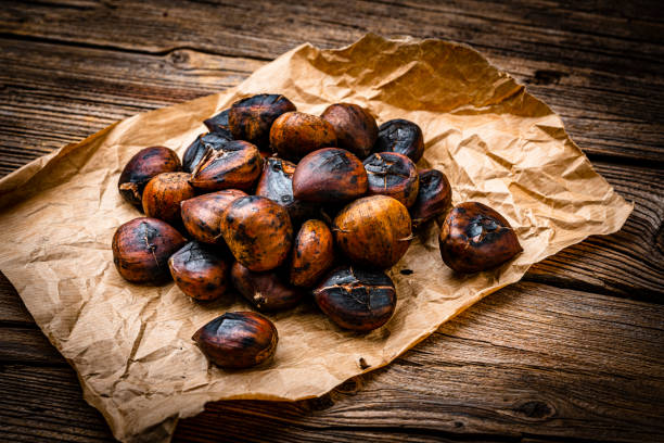 素朴な木製のテーブルで撮影されたローストして皮をむいたチェスナッツのクローズアップ - chestnut close up close to macro ストックフォトと画像