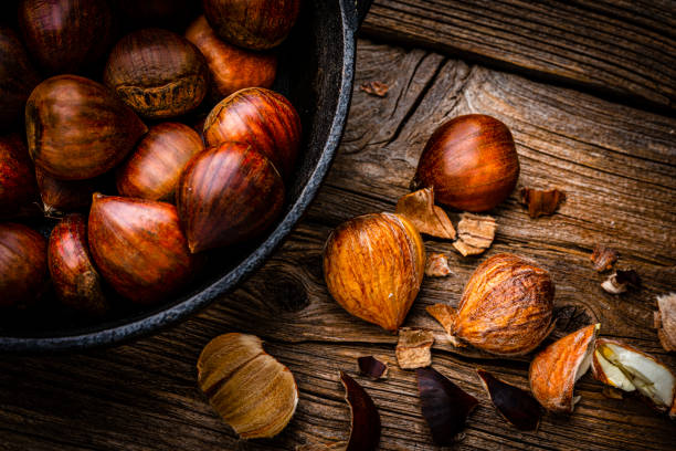 素朴な木製のテーブルで撮影された皮をむいたチェスナッツのクローズ アップ - chestnut close up close to macro ストックフォトと画像