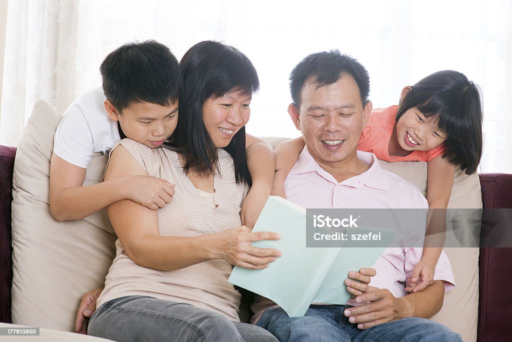 Os pais e crianças lendo livro em casa. - Foto de stock de Adulto royalty-free