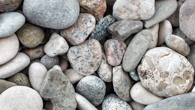 Pebbles, large round beach sea stones, moving sideways, close-up macro, top view