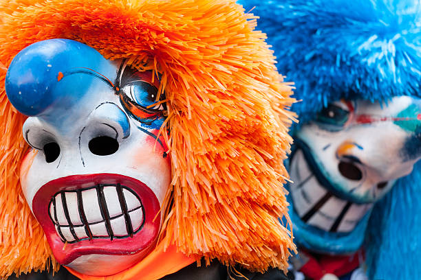 Traditional Waggis Masks At Fasnacht Festival Basel, Switzerland Two traditional waggis masks with orange and blue hair at fasnacht festival Basel, Switzerland. caricature photos stock pictures, royalty-free photos & images