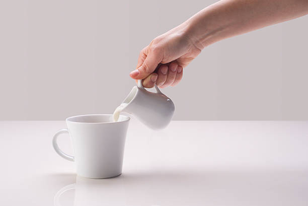 istock Hand pouring milk in coffee cup 177816337