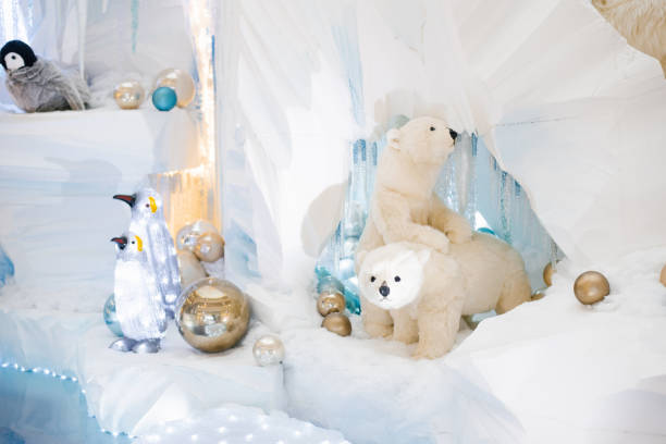 Christmas decor. Polar polar bears and penguins on an artificial iceberg in a cave