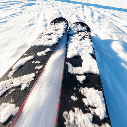 Close up of a pair of skis while skiing at speed.