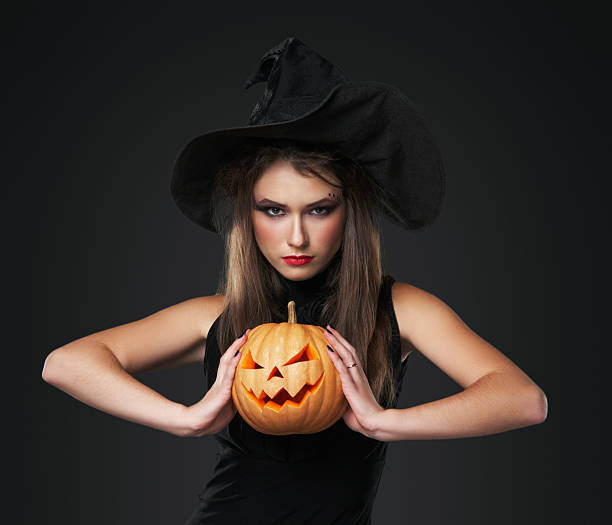 istock The serious girl is standing with pumpkin 177817631