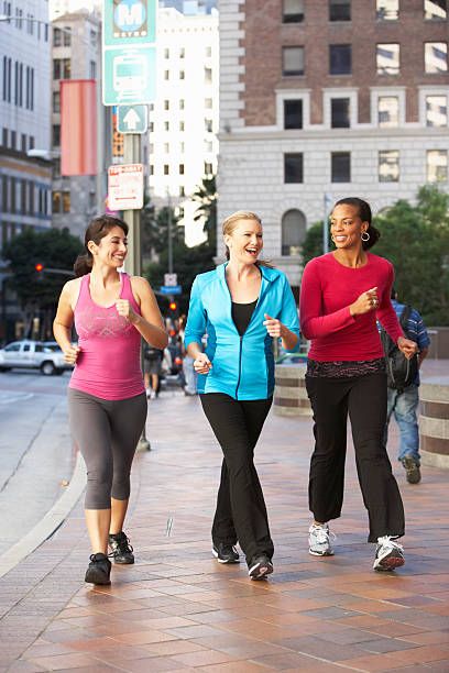 Three women power walking on urban street