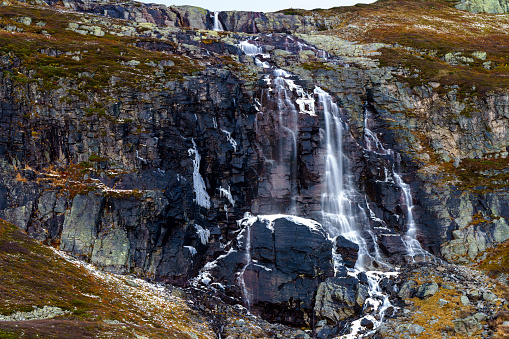 Waterfall in Norway in late autumn beginning to freeze