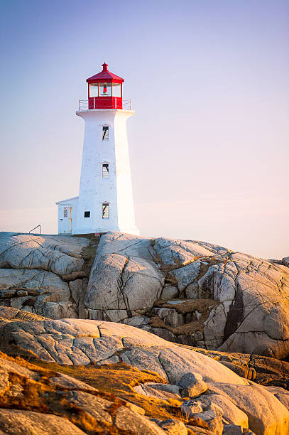 Peggys Cove Lighthouse in Nova Scotia The iconic Peggys Cove (alternate spelling Peggy's Cove) lighthouse in Nova Scotia, Canada. The lighthouse sits on 415 million year old granite, part of the Nova Scotia batholith. peggys cove stock pictures, royalty-free photos & images