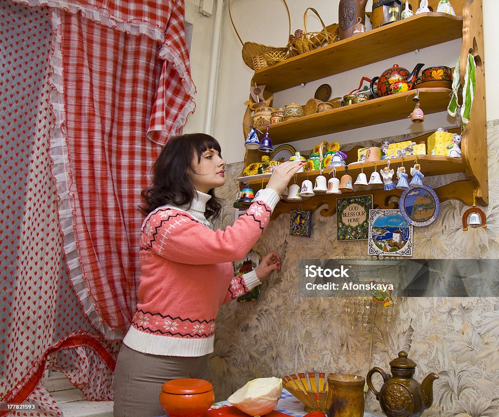 Kobieta w kuchni przyjmowanie dań z półki - Zbiór zdjęć royalty-free (Brązowy)