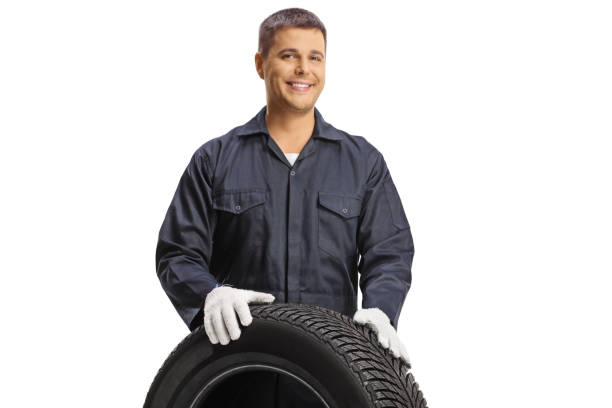 istock Young car mechanic behind a car tire 1778216105