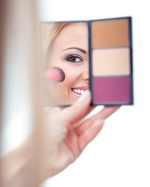 istock Woman applying cosmetics to her face 177822160
