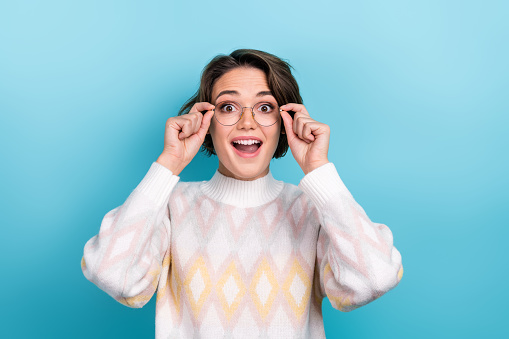 Photo portrait of lovely young lady touch eyewear excited astonished wear trendy white garment isolated on blue color background.
