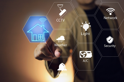 User hand reaches out to touch the network icon smart home technology to connect the system to the home appliances control and turn on and off even monitoring home by CCTV camera.