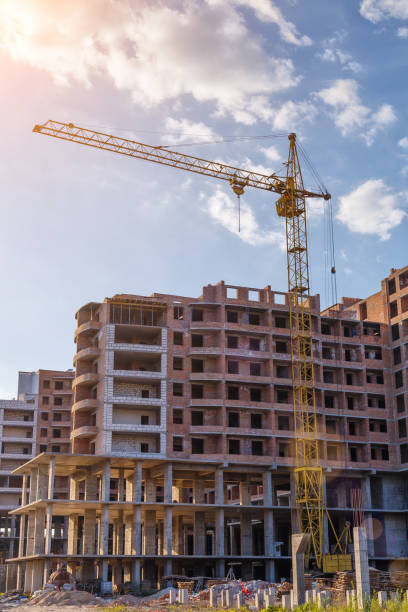 istock Tall building under construction with scaffolds,Freestanding tower crane on a building site.Building construction site work against blue sky 1778236015