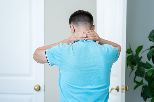 Neck pain, man suffering from ache at home, health problems concept