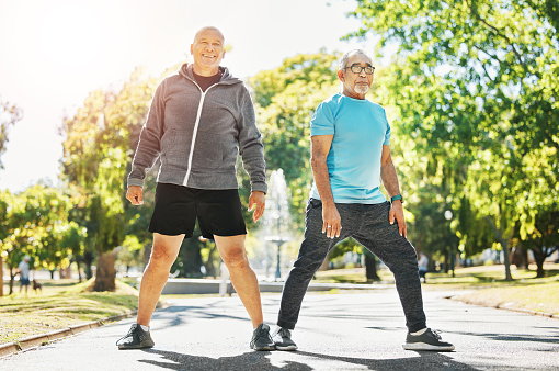 Happy senior man, friends and stretching in nature for workout, training or outdoor exercise together. Mature people in body warm, preparation or getting ready for cardio, running or fitness at park