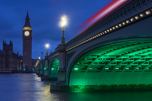 Big Ben and the illuminated Westminster Bridge over the Thames river at dusk; London, United Kingdom