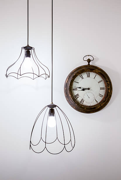 istock Vintage clock on a white wall with stylish lamps 177825467