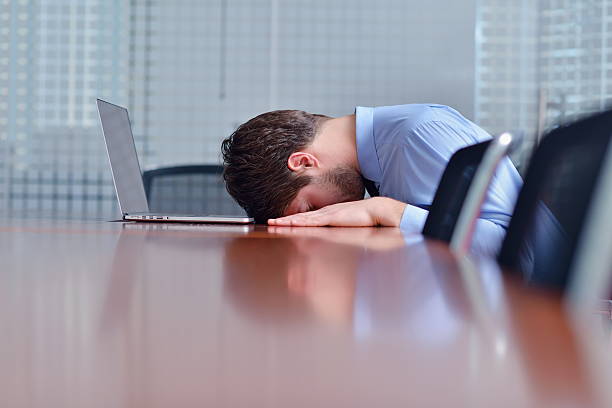 istock Businessman with head resting on table in front of laptop 177825564