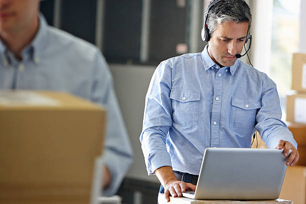 manager mit headset im auslieferungslager - leader of the pack stock-fotos und bilder