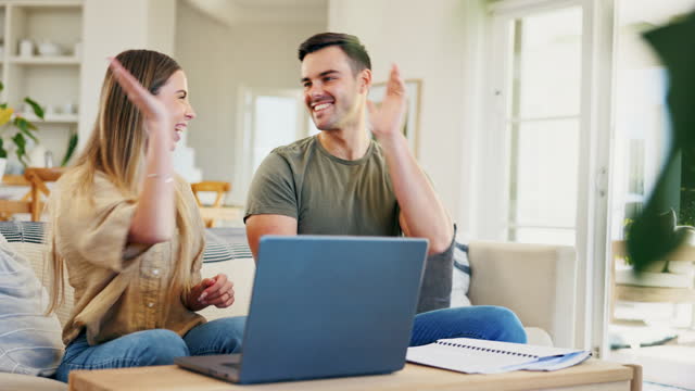 High five, budget and a couple with success and a laptop for teamwork in home finance planning. Excited, win and a happy young man and woman with paperwork, computer and a gesture for trading on a pc