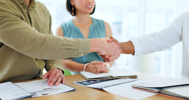 istock Business people, hand shake and documents for partnership deal, contract or agreement in company office. Shaking hands, men and woman after negotiation, meeting or collaboration for corporate work 1778268399