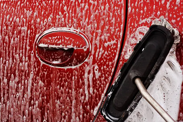 Washing the car with soapy soft brush at a car power wash