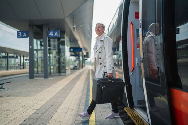 istock smiling mature woman with suitcase getting off train 1778287345