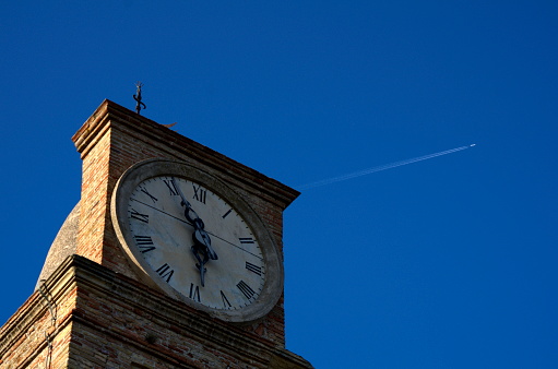 view of clock tower and airplane in sky