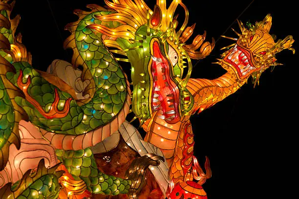 Giant dragon and snake shaped multicolored Asian lanterns glowing.