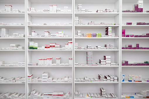 Prescription medicines stored in shelves at the pharmacy - pharmaceutical industry concepts