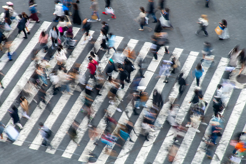 Birds eye view and blurred motion of pedestrians on crosswalk in rush hour in Tokyo, Japan, creating abstract image