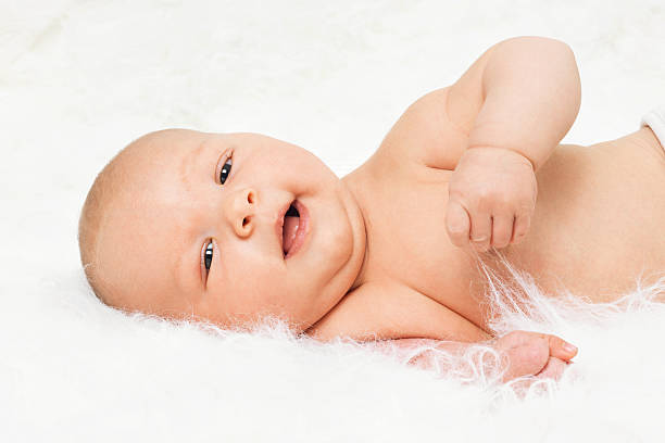 Cute baby boy lying on fur blanket stock photo