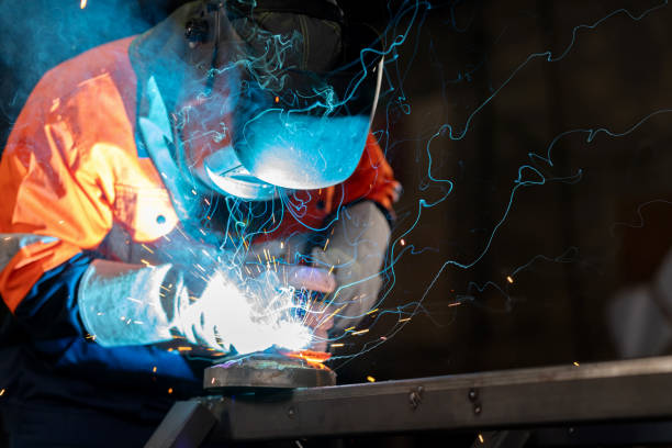 istock Skilled craftsman, dressed in a protective suit, stands determinedly in factory. Surrounded by the machinery of an industrial workshop, this craftsman is laser-focused on welding iron with precision and unwavering control, ensuring the good quality. 1778315281