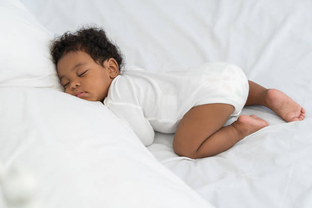 istock black african american baby sleeping on a white mattress. 1778324375