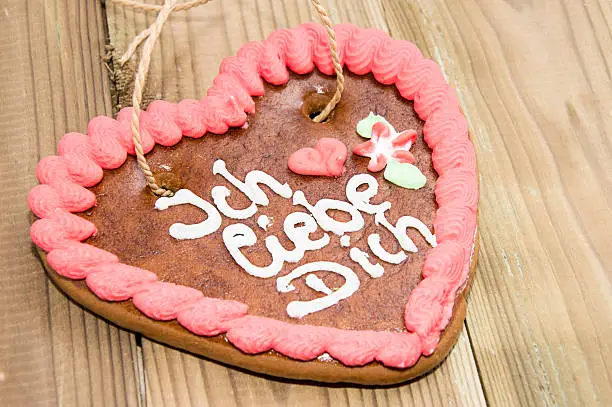 Gingerbread-Heart with I love you in German on wooden background