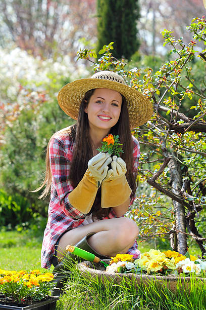 istock Beautiful gardener smiles with flower in hand 177833209