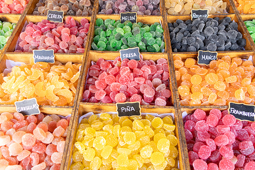 Colorful assortment of sugar homemade candies with different fruit flavors. Translated text (and types of sweets): gooseberry, mandarin, cherry, mango, pineapple, strawberry, raspberry, melon, licorice