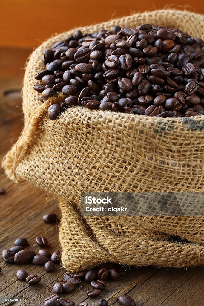 Leinen-Tasche mit Kaffeebohnen auf Holztisch - Lizenzfrei Braun Stock-Foto