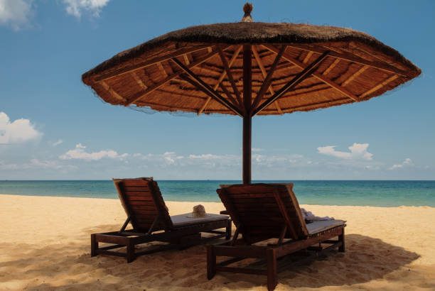 istock Wooden chairs and umbrellas on white sand beach 1778365453