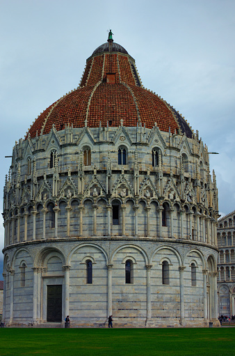 Picturesque landscape view of medieval Pisa Baptistery of St. John. It is Roman Catholic ecclesiastical building. Architectural icon of the city of Pisa, Italy. UNESCO World Heritage Site.