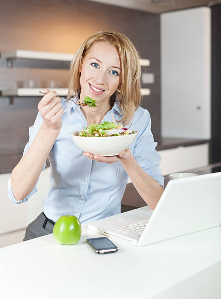 donna in cucina con insalata fresca - karriere foto e immagini stock