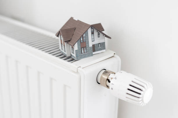 istock House model wrapped in scarf on radiator indoors, space for text. Winter heating efficiency 1778384759