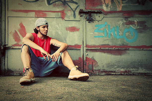 istock Young man sitting. Grunge graffiti wall 177838637