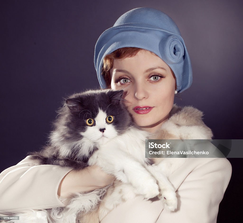 woman wearing grey felt hat in retro stlyle elegant woman wearing grey felt hat in retro stlyle holding cat .Glance of woman and cat is the same.  	Resembling,  	similarity. Felt - Textile Stock Photo