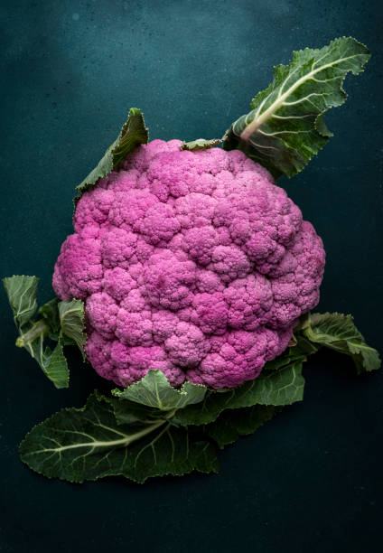 istock Fresh organic purple cauliflower cabbage with leaves on old rustic green table background, top view 1778390785