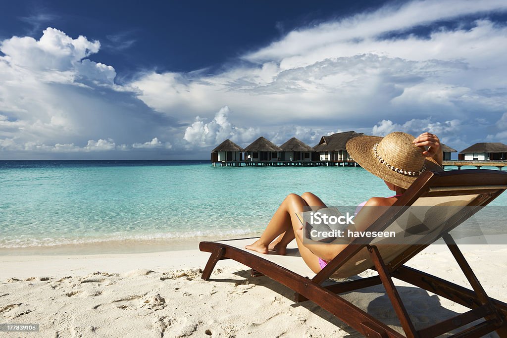 Junge Frau liest ein Buch am Strand - Lizenzfrei Blau Stock-Foto