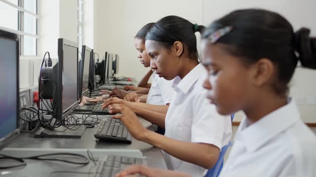 Female elementary students working on computers in a school classroom