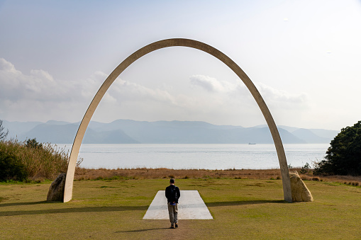 Naoshima Island, Japan- April 12, 2023; Person standing under Infinity gate of the Lee Ufan Museum designed by Tadao Ando, looking at the sea